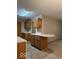 Kitchen features light oak cabinets and laminate countertop with a dining ledge separating it from living room at 989 Plaza Dr, Martinsville, IN 46151