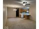 An open living space features neutral carpeting, ceiling fan, and adjacent kitchen with breakfast bar at 989 Plaza Dr, Martinsville, IN 46151