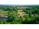 An aerial view displays a community with generous green spaces, mature trees, and residential properties at 10065 E 25Th St, Indianapolis, IN 46229