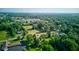 Aerial view showcases a community with homes nestled among mature trees and lush green spaces at 10065 E 25Th St, Indianapolis, IN 46229