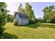 Backyard with shed, surrounded by green grass and mature trees, offering ample storage at 10065 E 25Th St, Indianapolis, IN 46229