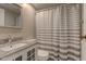 Cozy bathroom featuring a granite countertop and a stylish striped shower curtain at 10065 E 25Th St, Indianapolis, IN 46229