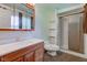 Well-lit bathroom with a vanity, toilet, and a shower enclosed by glass doors at 10065 E 25Th St, Indianapolis, IN 46229