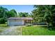 Single story home features a two car garage with a yard and driveway at 10065 E 25Th St, Indianapolis, IN 46229