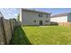 A well-maintained backyard with lush green grass, a wood fence, and the back of a two-story home at 10222 Arapahoe Dr, Indianapolis, IN 46235