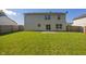 A spacious backyard with green lawn, wood fence, and a two-story home with sliding glass doors at 10222 Arapahoe Dr, Indianapolis, IN 46235