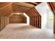 Unfinished attic with exposed beams and plywood subflooring, featuring natural light at 11250 N 600 W, Fountaintown, IN 46130