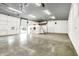Vast garage with concrete floor, white walls and doors, overhead lighting, ladder, and plenty of space at 11250 N 600 W, Fountaintown, IN 46130