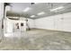 This spacious white garage has concrete flooring, high ceilings, ladders, and offers versatile potential at 11250 N 600 W, Fountaintown, IN 46130