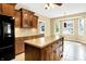 Bright kitchen with dark appliances, wood cabinets, a large center island, and tile flooring at 11250 N 600 W, Fountaintown, IN 46130