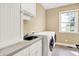 Well-lit laundry room with modern washer and dryer, sink and ample cabinet space at 11250 N 600 W, Fountaintown, IN 46130