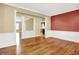 Open-concept living room with hardwood floors, decorative columns, and wainscoting details at 11250 N 600 W, Fountaintown, IN 46130