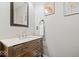 Updated half bathroom features a wood vanity with marble countertop and modern mirror at 11424 Green St, Carmel, IN 46033