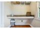 Bright laundry room featuring a built-in shelf, overhead storage and granite countertop at 11424 Green St, Carmel, IN 46033