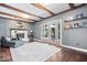 Bright living room boasts hardwood floors, beamed ceiling, fireplace, and french doors to the outdoor patio at 11424 Green St, Carmel, IN 46033