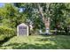 Backyard with storage shed and peaceful seating area under mature trees at 11424 Green St, Carmel, IN 46033