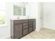 Bright bathroom features a double sink vanity with framed mirror, vinyl floors, and bright lighting at 1156 Brockton Ct, Greenfield, IN 46140
