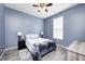 Cozy bedroom with a ceiling fan, a window, a bed with lamps, and wood grain floors at 1187 Blackthorne S Trl, Plainfield, IN 46168
