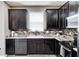 Well-appointed kitchen featuring dark cabinets, sleek countertops, and modern fixtures and appliances at 1187 Blackthorne S Trl, Plainfield, IN 46168