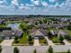 Aerial view of a residential neighborhood featuring a pond, well-maintained lawns, and mature trees at 1201 Fantail Dr, Greenwood, IN 46143