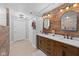 Double vanity bathroom with a wood accent wall, and sinks, and bright lighting at 1201 Fantail Dr, Greenwood, IN 46143