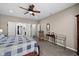 Bright main bedroom featuring neutral walls, a ceiling fan, and an adjacent seating area at 1201 Fantail Dr, Greenwood, IN 46143