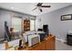 A spacious home office with a ceiling fan, a large desk, and bright, natural light at 1201 Fantail Dr, Greenwood, IN 46143