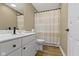 Neutral bathroom with white vanity, black hardware, and tile-look laminate flooring at 12214 Ridgeside Rd, Indianapolis, IN 46256