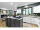 Spacious kitchen with white cabinets, hardwood floors, an island, and views to the fireplace at 12214 Ridgeside Rd, Indianapolis, IN 46256