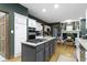 Open kitchen with stainless appliances, island cooktop, and easy access to the fireplace at 12214 Ridgeside Rd, Indianapolis, IN 46256