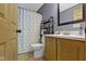 A bathroom with tile floors, honey comb shower curtain, and a wood vanity with marble countertop at 12222 Cable Dr, Indianapolis, IN 46236