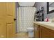 A bathroom with tile floors, honey comb shower curtain, and a wood vanity with marble countertop at 12222 Cable Dr, Indianapolis, IN 46236