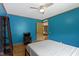 Bedroom featuring blue walls, ceiling fan, hardwood floors, shelving, and a comfortable bed at 12222 Cable Dr, Indianapolis, IN 46236