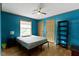Bright bedroom with blue walls, ceiling fan, hardwood floors, shelving, and a neutral bedspread at 12222 Cable Dr, Indianapolis, IN 46236
