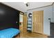Bedroom boasts hardwood floors, black accent wall, ceiling fan, shelving, and two wooden doors at 12222 Cable Dr, Indianapolis, IN 46236