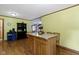 Kitchen island with seating, hardwood floors, and a view into the adjoining living spaces at 12222 Cable Dr, Indianapolis, IN 46236
