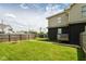 Grassy backyard showcasing ample space, a stone fire pit, and sturdy wooden fence at 1302 Main St, Elwood, IN 46036