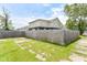 Large fenced backyard featuring green grass with scattered concrete pads at 1302 Main St, Elwood, IN 46036