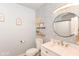 Stylish bathroom featuring patterned wallpaper, floating shelves, and a round mirror above the vanity at 1302 Main St, Elwood, IN 46036