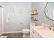 Stylish bathroom featuring patterned wallpaper, floating shelves, a round mirror above the vanity and a tub at 1302 Main St, Elwood, IN 46036
