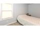 Cozy bedroom with neutral walls, soft carpet, and natural light from a large window at 1302 Main St, Elwood, IN 46036
