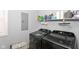 Functional laundry room with modern washer and dryer, shelf storage, and window at 1302 Main St, Elwood, IN 46036