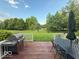 Inviting back deck featuring a grill, outdoor dining set, and serene backyard views at 13221 Griffin Run, Carmel, IN 46033
