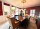 Well-lit dining room with a chandelier, and dining table with access to foyer through large archway at 13221 Griffin Run, Carmel, IN 46033