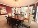 Formal dining room featuring a chandelier, dark wood table with seating for eight, and unique red wall color at 13221 Griffin Run, Carmel, IN 46033
