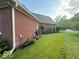 Side of the brick home featuring well-maintained landscaping and a manicured lawn at 13221 Griffin Run, Carmel, IN 46033