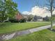 Charming two-story brick home with a lush green lawn and mature trees at 13221 Griffin Run, Carmel, IN 46033