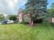 Beautiful brick home showcasing meticulous landscaping and mature trees in front yard at 13221 Griffin Run, Carmel, IN 46033