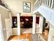 Inviting foyer with hardwood floors leading to a dining room with elegant chandelier and staircase with white trim at 13221 Griffin Run, Carmel, IN 46033