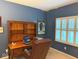 Comfortable office featuring a wooden desk and shelving next to plantation shutters at 13221 Griffin Run, Carmel, IN 46033